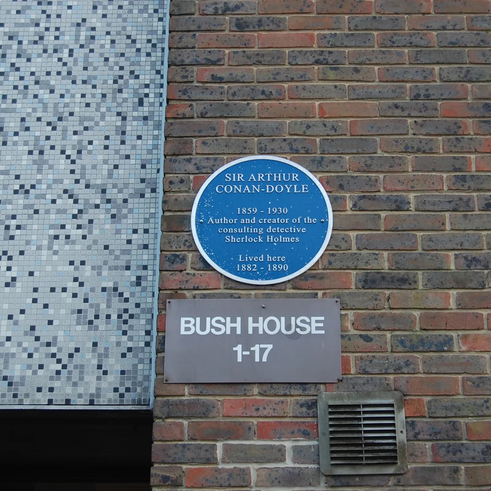 A blue plaque on a brick building indicates Sir Arthur Conan-Doyle lived there between 1882 and 1890, with a grey sign for Bush House below it.